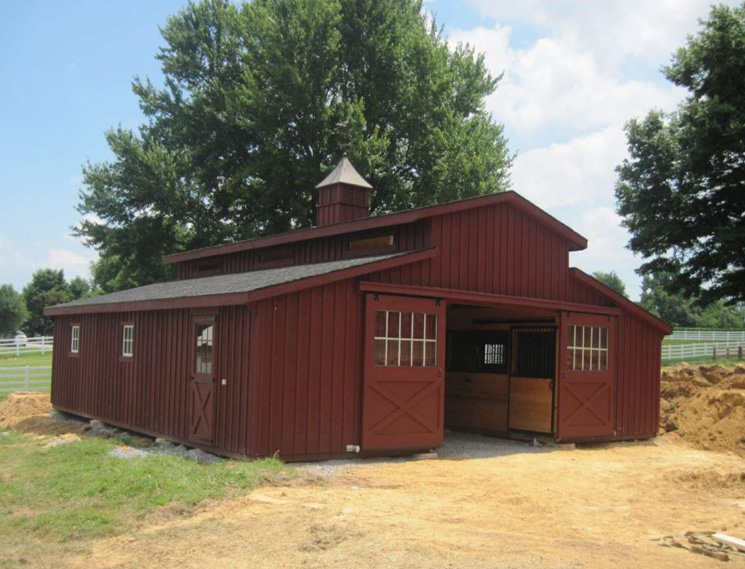 Red single story center aisle custom barn