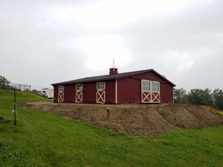 custom red horse barn with tan trim