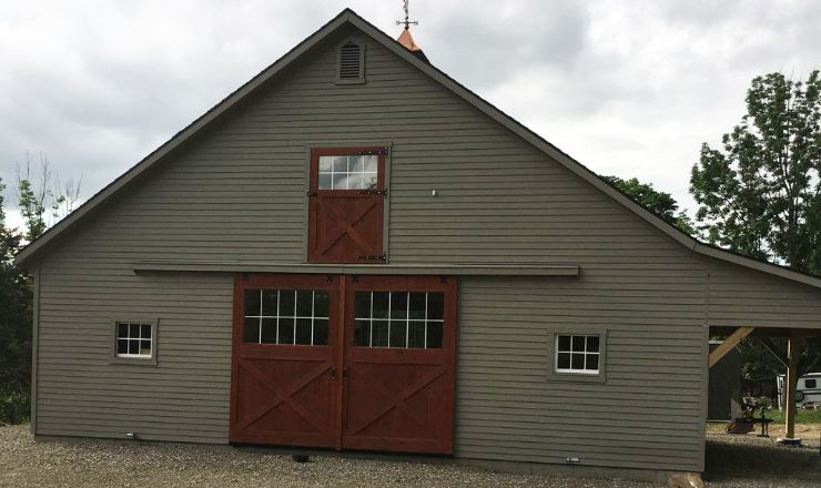 Green barn with natural wood doors