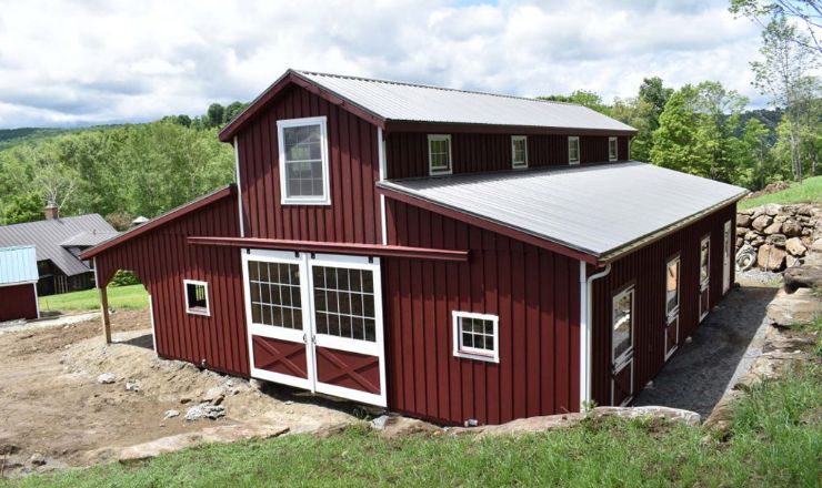 Red two story horse barn with white trim