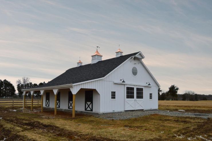 black and white high country style horse barn with lean to