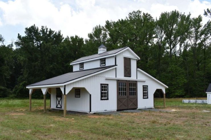 white high country style barn with brown trim and two lean-tos