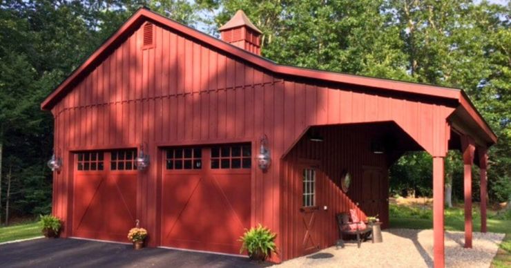 red prefab garage with two garage doors and lean to with driveway