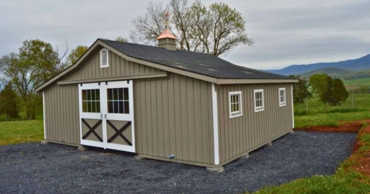 small trailside garage with sliding dutch barn doors and cupola on a cloudy day