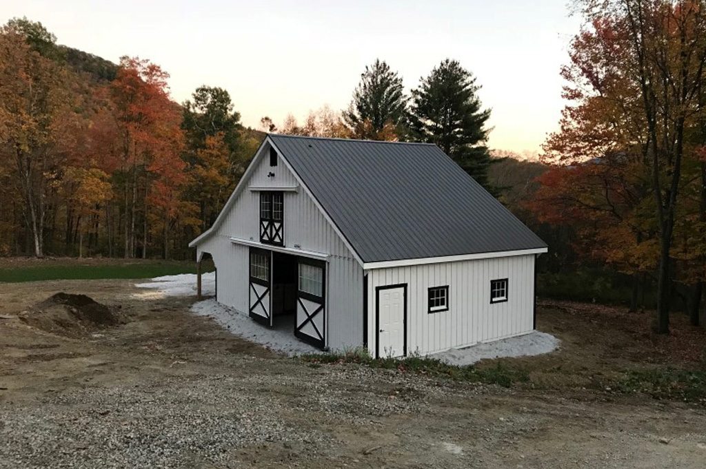 A classic center aisle horse barn with a metal roof